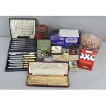 A collection of assorted costume jewellery, cased flatware and vintage advertising tins,