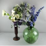 A green glass bottle garden, a vase and silk flowers. Largest; 44cm high.