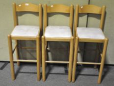 A set of Three beech wood bar stools, faux leather seat,