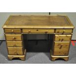 A pine pedestal desk with leather inset top,