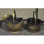 Two late 19th Century brass coal buckets with swing handles atop. Largest; 43cm high.