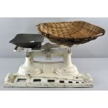An enamelled set of cast iron shop scales with wicker basket,