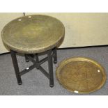 An Islamic Brass topped tray top table, raised upon a folding Oak base, 60cm high x 59cm,