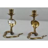 A pair of 20th century Benares brass candlesticks in the form of Cobra's,