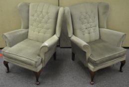 A pair of period style wing armchairs with mahogany legs,