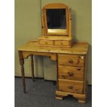 A pine dressing table/desk with a three drawer section to the right with turned legs,