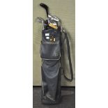 A golf bag together with some vintage clubs