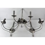 A group of three blackened/finished steel wall sconces, each with two bowls to fancy arms,