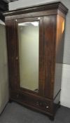 An Edwardian mahogany single, mirror door wardrobe,