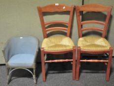 A pair of rush seat ladder back chairs together with a child's Lloyd Loom chair. Tallest; 88cm.