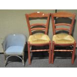 A pair of rush seat ladder back chairs together with a child's Lloyd Loom chair. Tallest; 88cm.