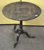 An early 19th century circular tilt top table with later carved decoration,