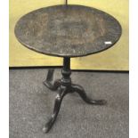 An early 19th century circular tilt top table with later carved decoration,