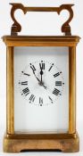 A French brass carriage clock, the enamelled dial on a brass, eight day movement,