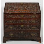 A George III oak bureau, late 18th century, with fitted interior, later carving to the front,
