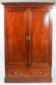 A Victorian mahogany wardrobe, circa 1880, with moulded cornice above two panelled doors,