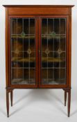 An Edwardian walnut and satinwood inlaid display cabinet, with leaded glass doors,