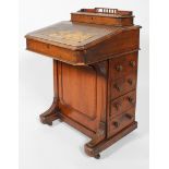 A Victorian oak davenport, the top opening to reveal stationery compartments,