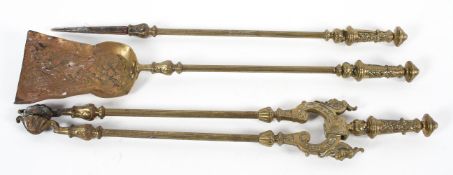 A three piece fire iron set, with foliate cast handles, and an embossed shovel,