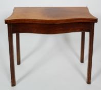 A George III mahogany and line inlaid serpentine fold out card table, with moulded legs,