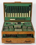 An Art Deco style oak cased, silver plated canteen of cutlery for Geo Wostenhlm,
