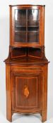 A Regency style mahogany corner cabinet, inlaid cross banding and shell decoration, with glazed top,