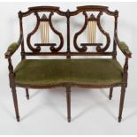 A Regency style two seat canape, with lyre back rests, serpentine seat and tapering fluted legs,