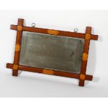 An Arts and Crafts style mirror with a notched wooden frame,