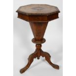 A Victorian walnut sewing table of octagonal form, the lid adorned with inlaid detailing,