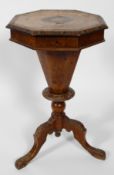 A Victorian walnut sewing table of octagonal form, the lid adorned with inlaid detailing,