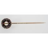 A yellow metal tie pin of circular design set with cabochon cut agate and rose cut diamonds.