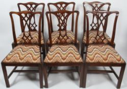 Six George III style mahogany dining chairs, each with carved interlocking pierced splat,