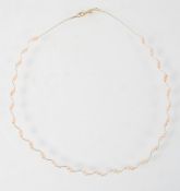 A yellow metal wire collar necklace having inter spaced pairs of freshwater pearls. Trigger clasp.