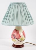 A Moorcroft lamp of bluster form, decorated with pink magnolia on a cream ground,