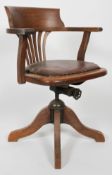 An oak Captains chair with swivel seat on quadripartite base,