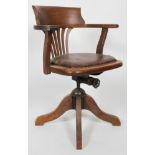 An oak Captains chair with swivel seat on quadripartite base,