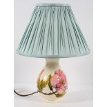 A Moorcroft table lamp of baluster form, decorated with pink magnolia on a cream ground, Stamped,