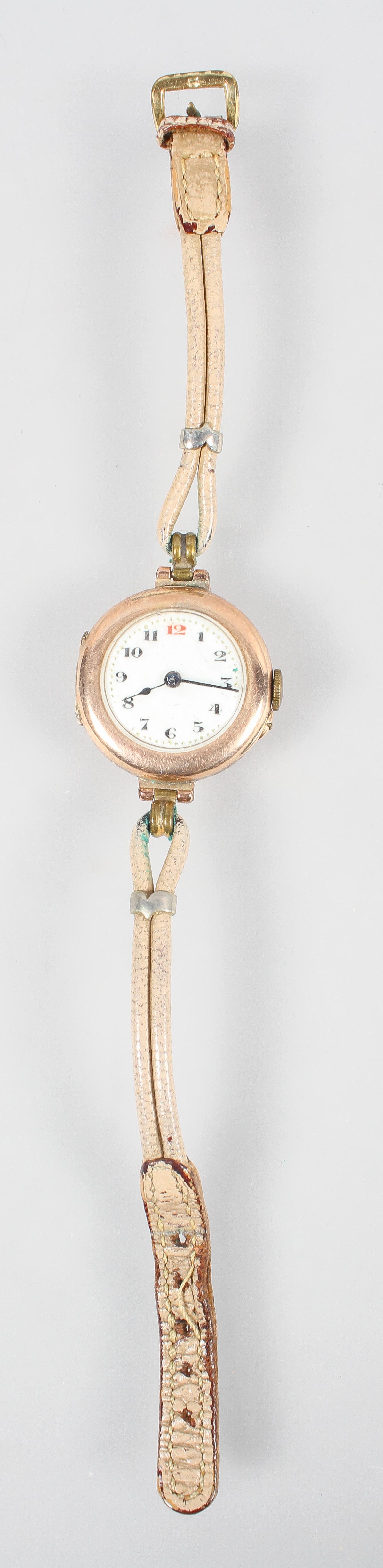 A rose metal wristwatch. Circular white dial with numerical markings. Mechanical movement.