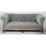 A Victorian Chesterfield sofa, with buttoned blue velvet upholstery and turned front legs,