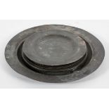A Georgian pewter charger, with plain rim, 38cm diameter; and six pewter plates,