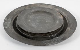 A Georgian pewter charger, with plain rim, 38cm diameter; and six pewter plates,