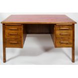A mid 20th century vintage golden oak twin pedestal desk having a red leather top,