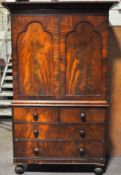 A Victorian Mahogany linen press, two arched doors enclosing slides,