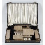 An Art deco style silver mounted dressing table set, comprising brushes, hand mirror and comb,