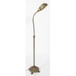 An early 20th century brass adjustable floor lamp, with shell shaped shade and adjustable stem,