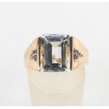 A yellow metal ring principally set with a rectangular cut colourless beryl (goshenite)