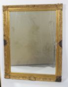 A gilt framed wall mirror, the rectangular bevelled plate inside a foliate moulded frame,