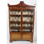 A George III mahogany display cabinet with glass front, flowing pediment,