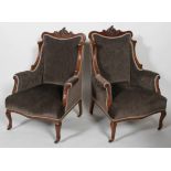 A pair of Edwardian walnut armchairs, with carved foliate crest,