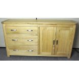 A modern oak sideboard with three drawers to one side and a cupboard with two doors to the other,